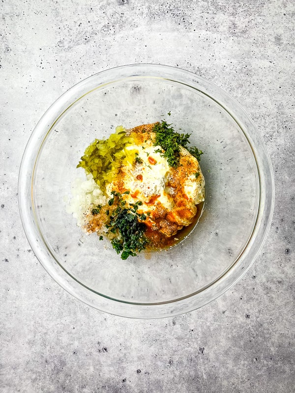 Tartar sauce ingredients inside clear bowl