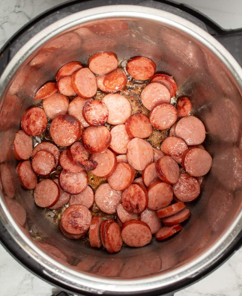 Overhead view of sliced sausage browned in Instant Pot.